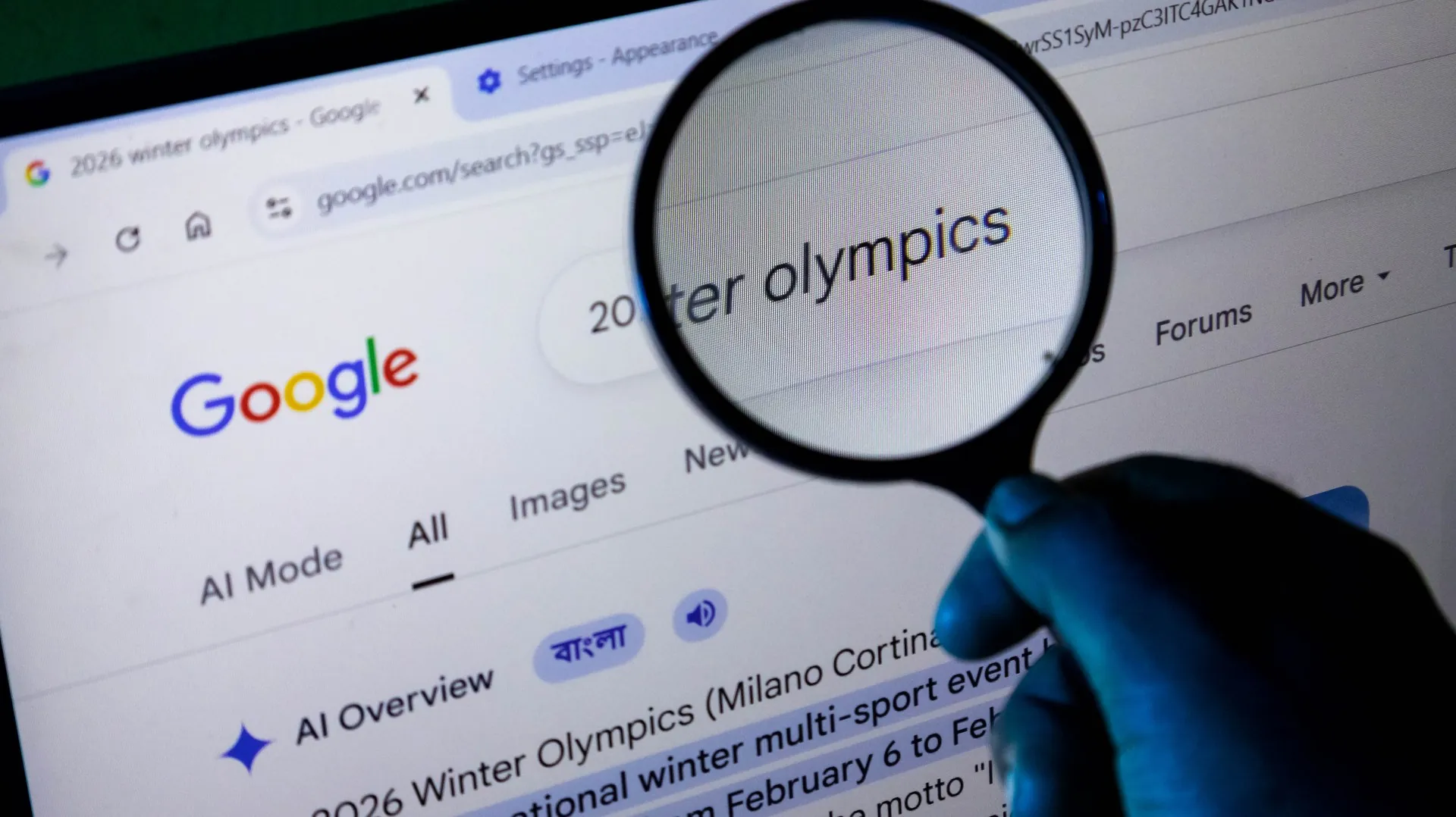 Écran avec une page de recherche Google et une loupe posée au-dessus pour mettre en avant une recherche et la réponse de l'IA Overview de Google.